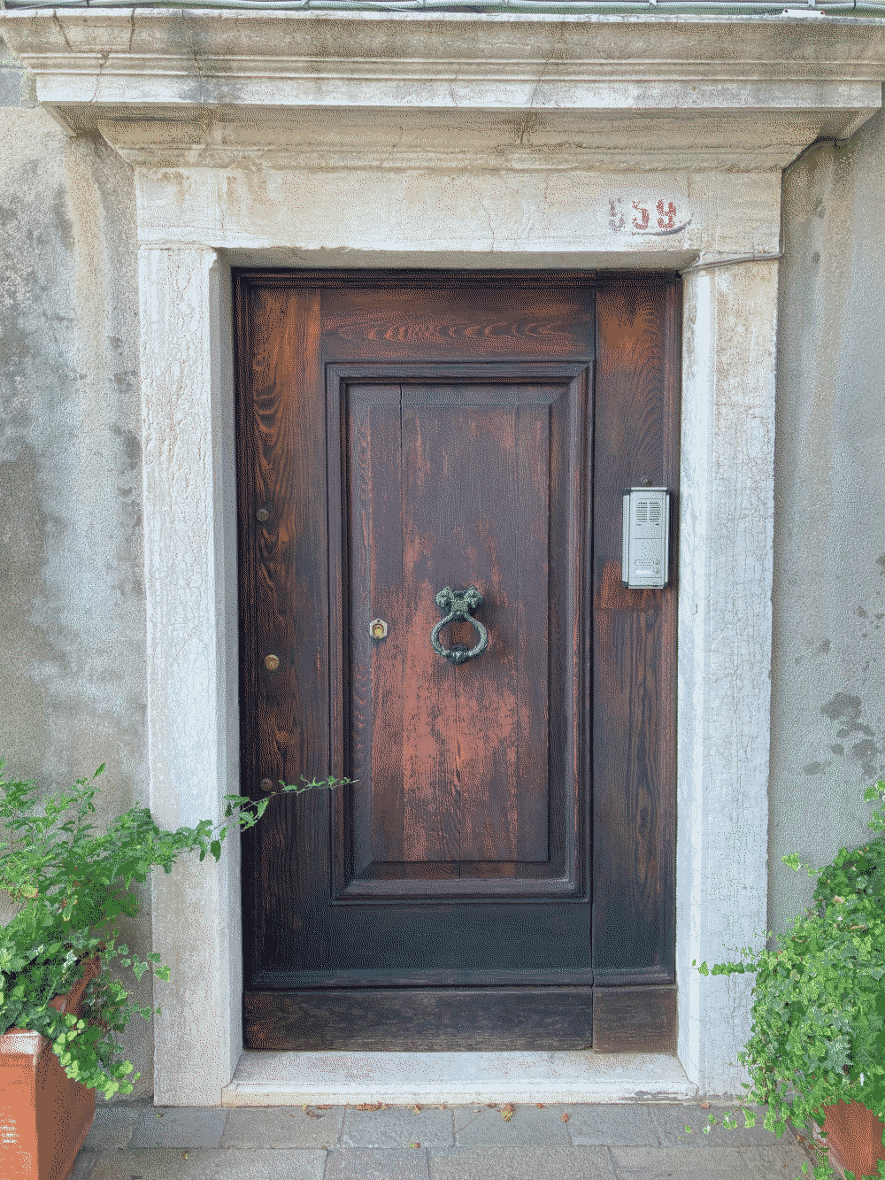 A coin sits in the keyhole of a great wooden door.