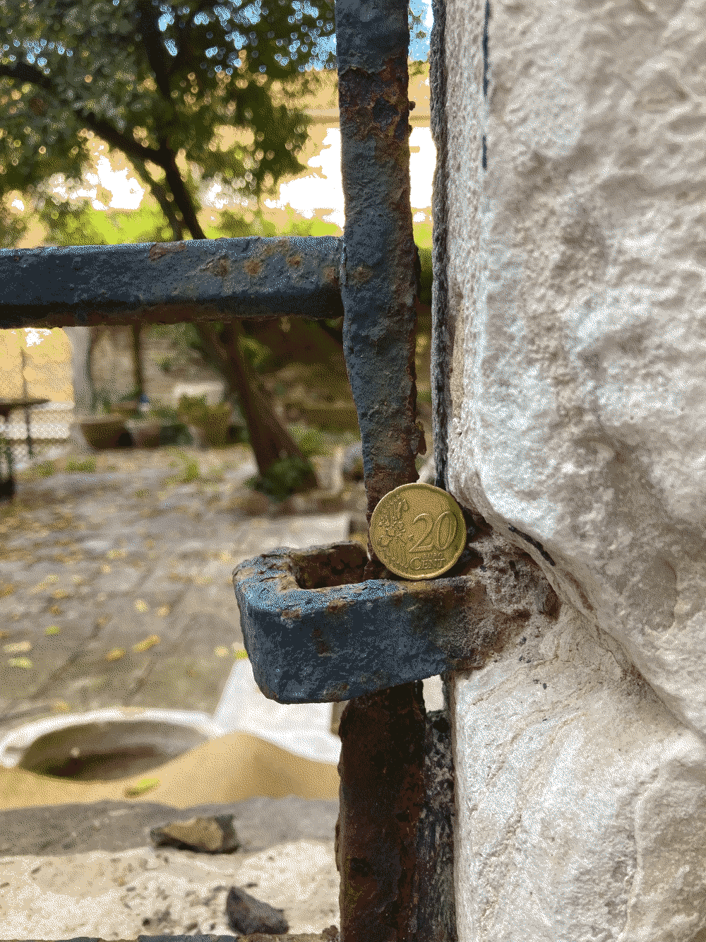 A coin sits against a wrought-iron gate.
