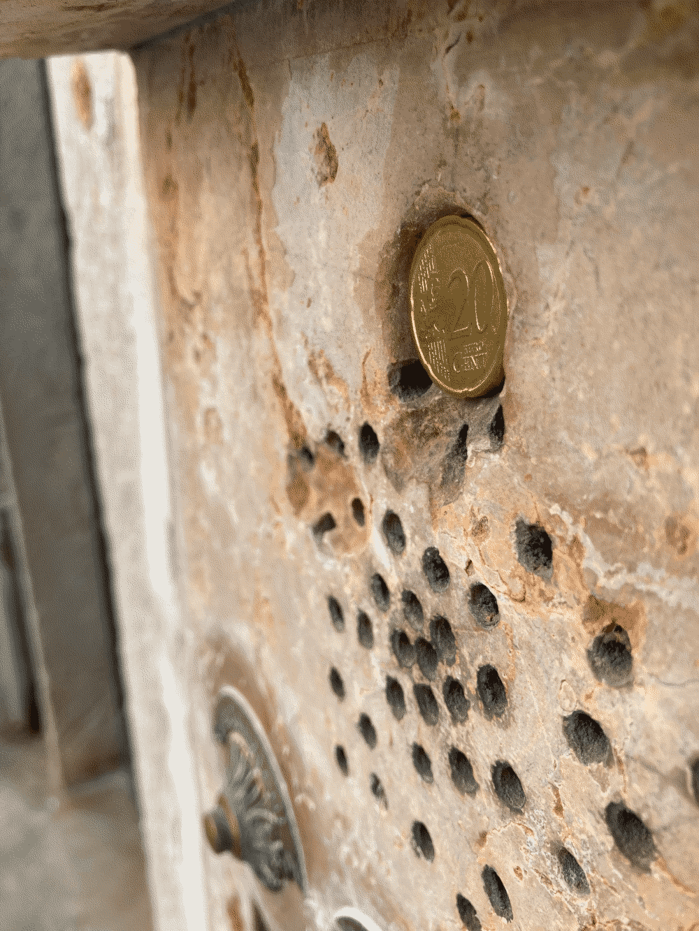 A coin fits nicely in a little hole in the wall.