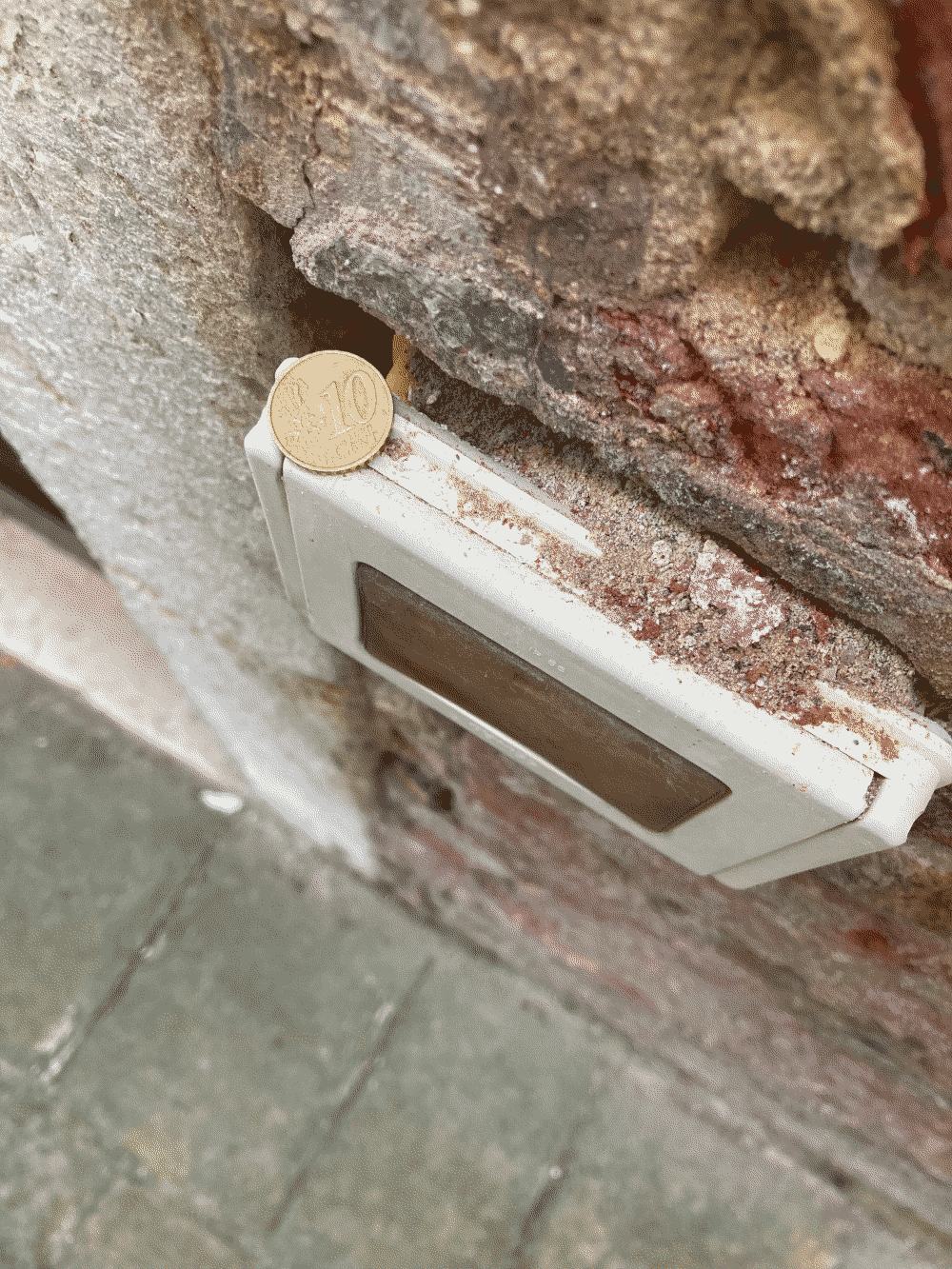 A coin sits precariously on top of an apartment intercom interface.