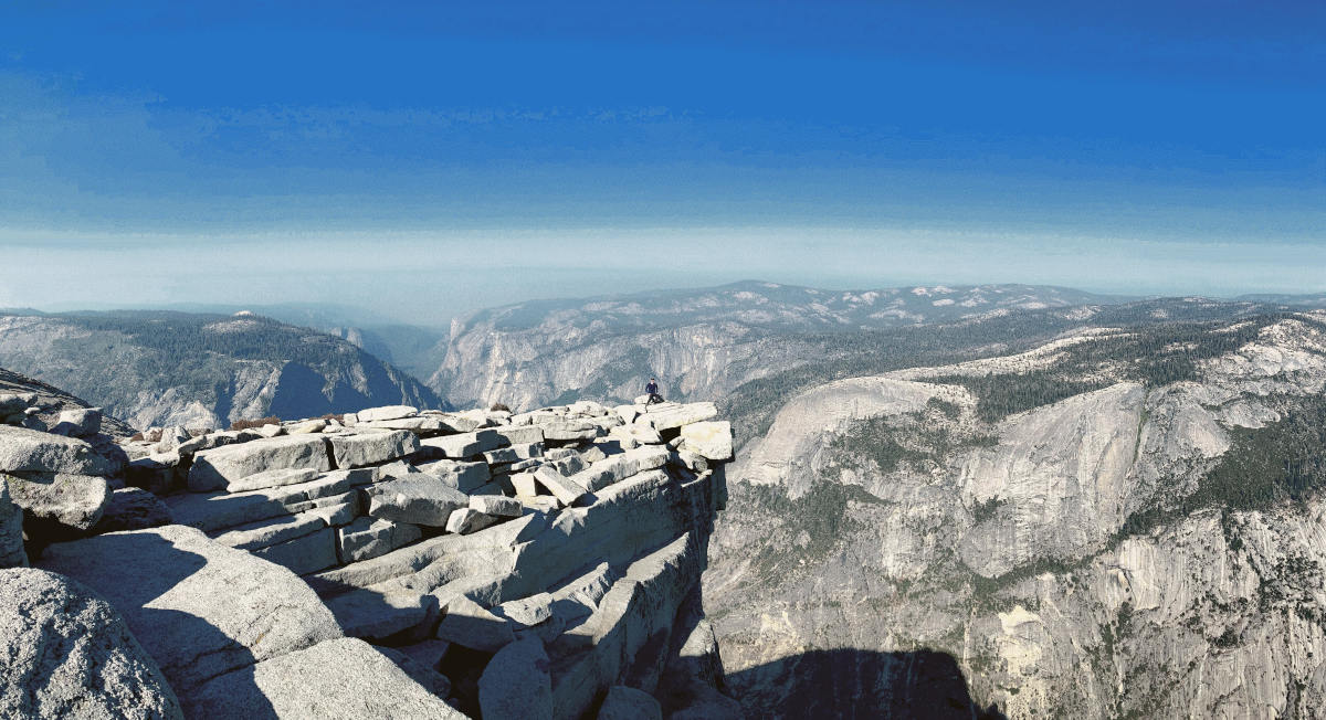 Me on top of half dome, with an enormous vista behind me.