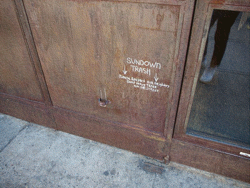 A handwritten notice on the wall of a bar asking patrons not to leave trash on the street.