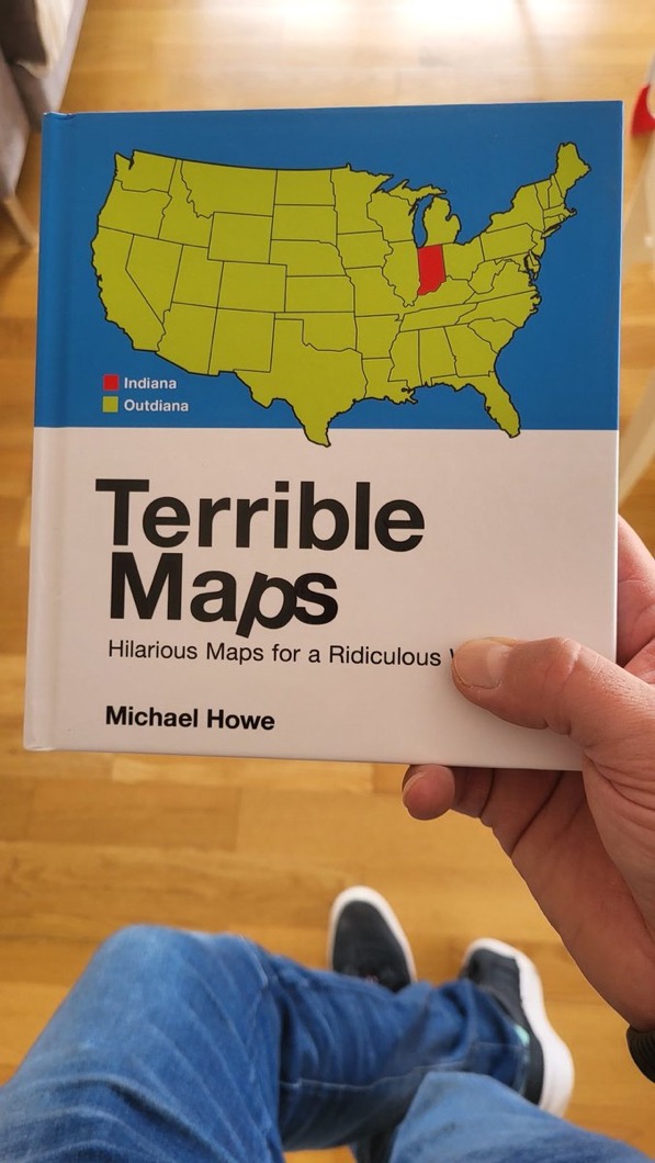 A man holds a book called Terrible Maps, with a map on the front highlighting Indiana inside the USA, and a key which says the highlight color is Indiana, and the rest is so-called Outdiana. I think it is super funny.